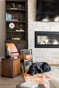Black Lab laying in custom designed living room with mounted TV