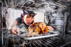 Woman taking out a burnt turkey from the oven